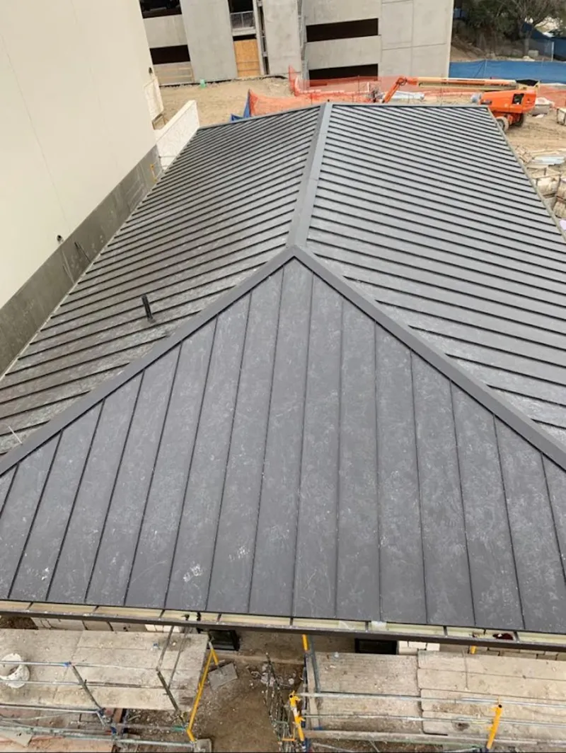 Commercial metal roof construction with crane equipment in Rochester
